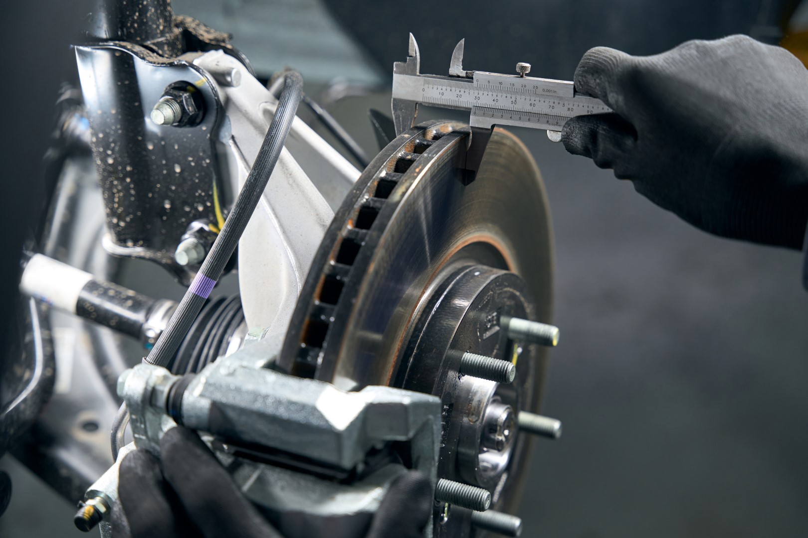 Mechanic measuring a car's calipers